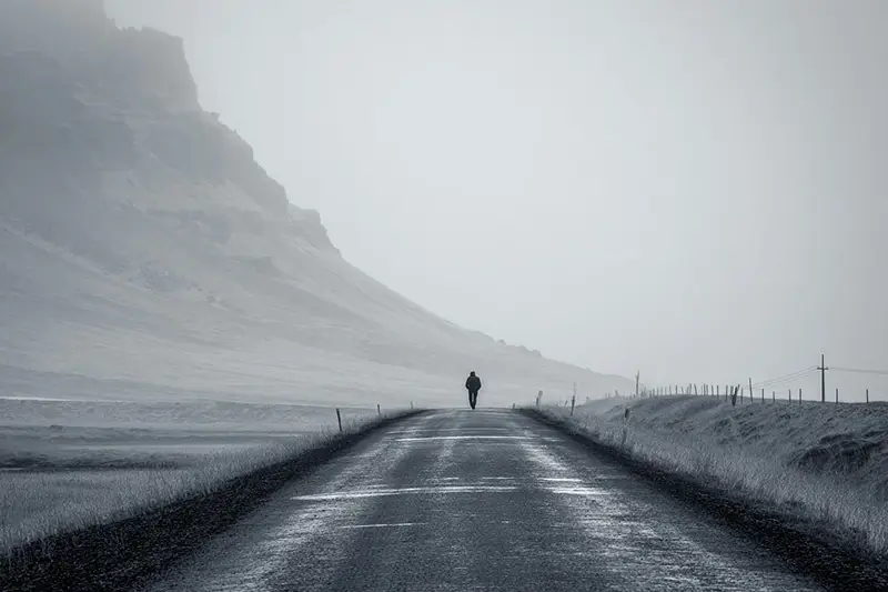 lonely figure facing endless road